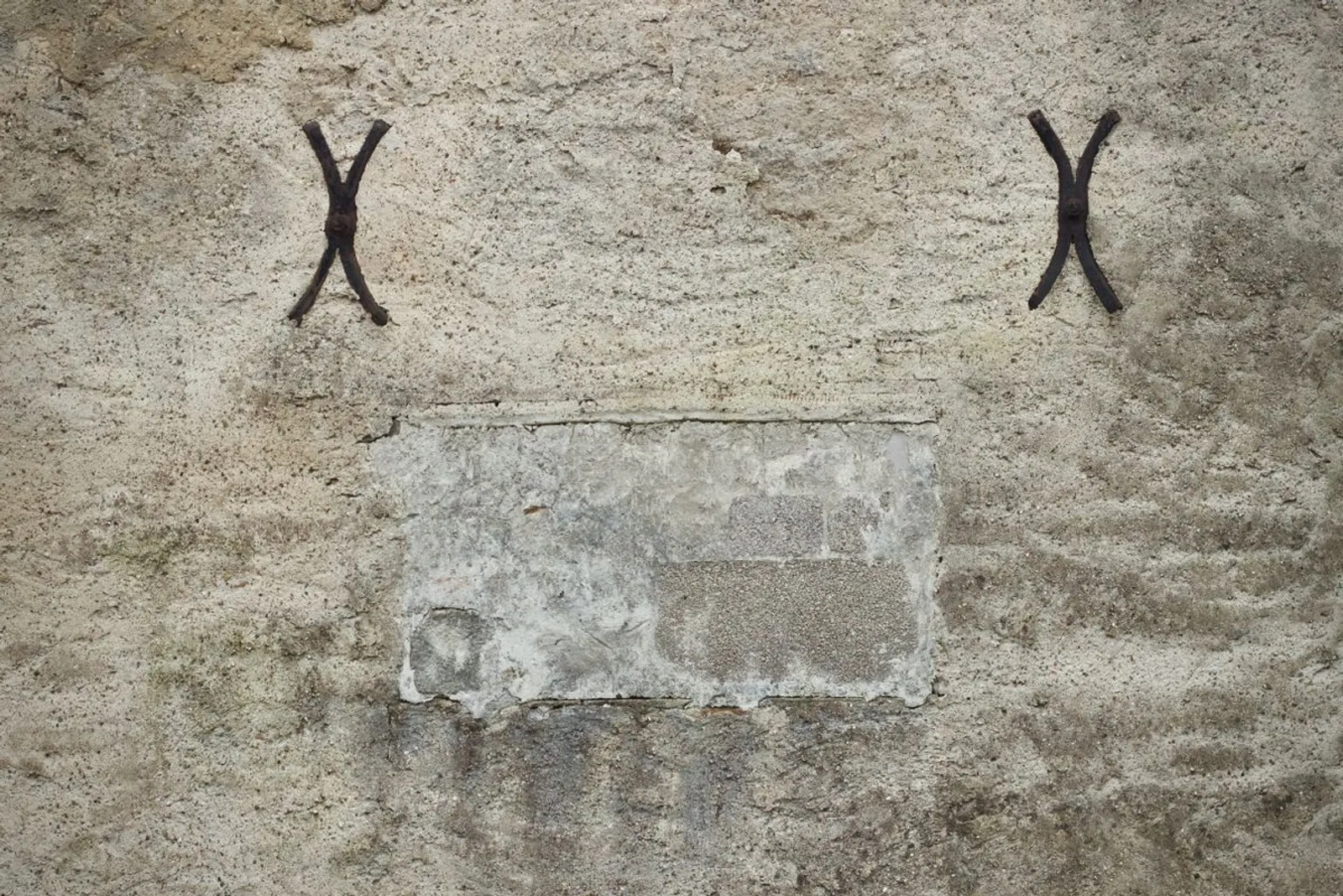 Gros plan sur des ancres de fixation en fer sur un mur en pierre ancien