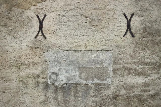 Close-up of iron wall anchors on an old stone wall